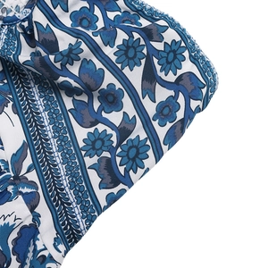 Détail de l'imprimé floral bohème bleu sur tissu en coton blanc avec motifs géométriques
