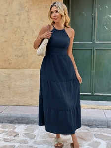 Detail of dark blue halter maxi dress showing tiered skirt and textured fabric