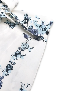 Detail of bohemian floral print on high-waisted wide-leg trousers with tie-front belt