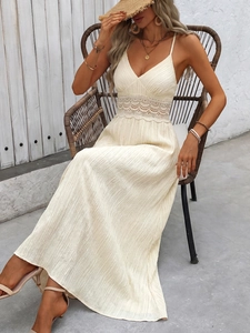 Detailed view of bohemian beige maxi dress featuring lace patchwork and pleated fabric