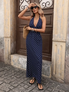 Detail of navy blue polka dot maxi dress featuring a halter neck and deep V-neckline