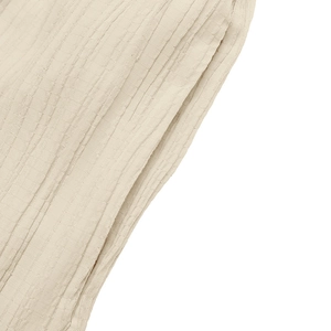 Detail of the sleeveless jumpsuit showing vertical textured fabric and side pocket