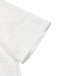 Gros plan sur le tissu d'un t-shirt blanc avec détails de texture jacquard papillon
