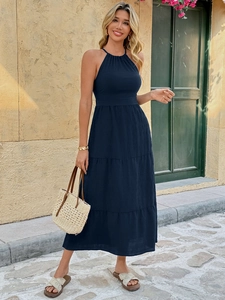 Detail view of the halter neck backless navy maxi dress with pleated tiered skirt design