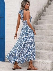 Detail of blue geometric print on white halter neck maxi dress with open back design