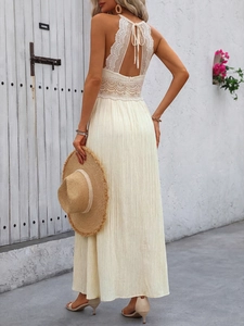 Elegant backless detail of halter lace dress with ties and pleated skirt in cream
