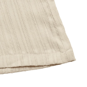Detailed macro view of off-white crinkle texture fabric and professional hem stitching