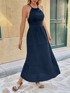 Detail of navy blue halter maxi dress with waist cinching and tiered pleated fabric texture