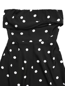 Détail de pois blancs sur une combinaison bustier noire avec un design de buste plissé