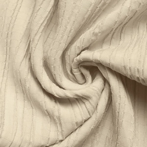 Macro shot of cream sleeveless jumpsuit fabric showing vertical waffle texture detail