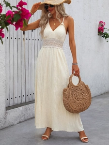 Close-up of white bohemian maxi dress featuring intricate lace hollow-out waist and pleated texture
