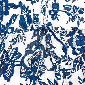 Detail of waist drawstring and white buttons on a floral print summer dress
