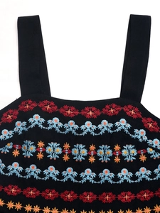 Close-up of vibrant multi-color embroidery on a black square-neck sleeveless romper
