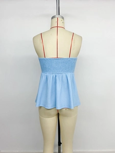 Detail of sky blue textured tank top featuring red spaghetti straps and smocked back panel