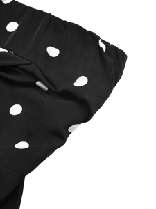 Gros plan détaillé du tissu noir à pois blancs avec coutures élastiques sur les bords
