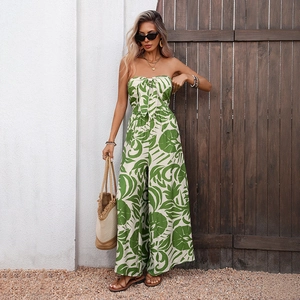 Elegant sleeveless strapless jumpsuit featuring green tropical leaf print and bow detail