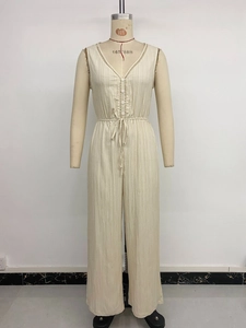 Detail of beige sleeveless jumpsuit with textured fabric and drawstring waist design