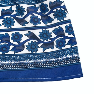 Detailed macro view of the bohemian floral print hemline and stitching on the dress