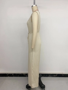 Close-up of cream white sleeveless jumpsuit showing pleated fabric texture and high waist detail