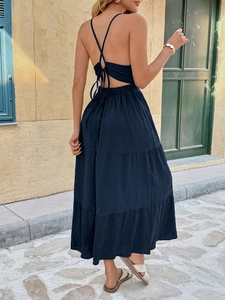 Detail of navy blue tiered halter dress with cross-back lace-up design in summer resort style