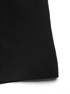 Close-up of black woven fabric texture and neat stitching on bohemian summer jumpsuit