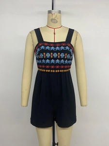 Detail of ethnic embroidery and vibrant patterns on a black sleeveless summer jumpsuit