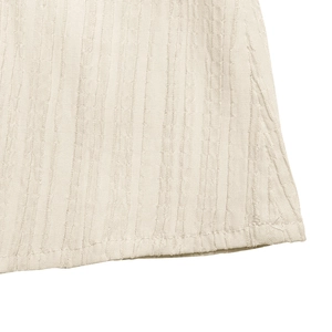 Detailed macro view of plissé fabric texture and stitching on summer halter dress