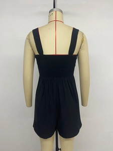 Detail view of the smocked back panel on a black sleeveless summer romper for women