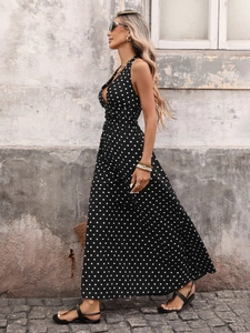 Detail of elegant black and white polka dot halter maxi dress with deep V-neck and high waist