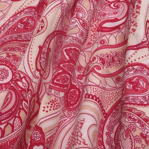 Macro de tissu à motif paisley rouge montrant la texture douce du coton et le tissage