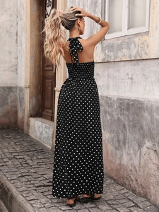 Detailed back view of a black polka dot halter maxi dress with smocked elastic waist