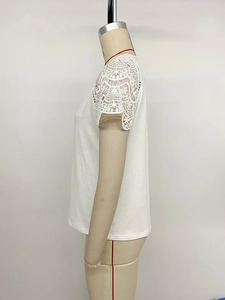 Detailed close-up of white lace patchwork on short sleeve cotton blend summer T-shirt