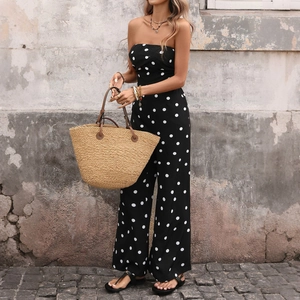 Tuta intera a pois nera senza spalline con gamba larga e borsa in paglia stile vintage