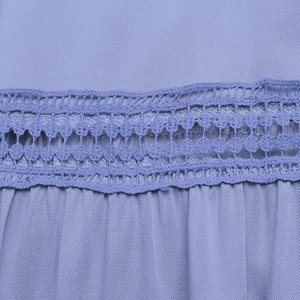 Detail of lavender dress featuring intricate lace stitching and delicate pleated fabric