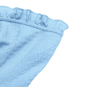 Close-up of light blue seersucker fabric texture with ruffle edges on a slim fit crop top