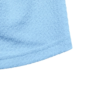 Close-up detail of light blue knitted fabric with textured waffle weave and neat stitching