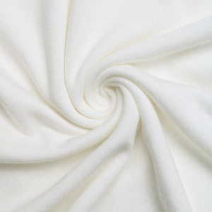 Detailed macro view of pure white soft knit fabric with delicate lace texture on top