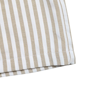 Close-up of the khaki striped linen fabric texture and hem stitching on a jumpsuit