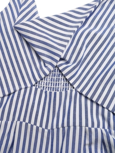 Dettaglio macro del tessuto a righe bianche e blu con punto smock e cuciture elastiche