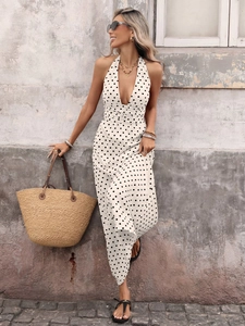 Detail of white polka dot halter maxi dress with a deep V-neck and flowing fabric