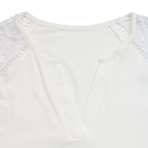 Close-up detail of white V-neck top featuring intricate lace patchwork on shoulders