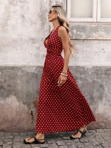 Detail of red polka dot halter maxi dress with deep V-neck and flowing summer fabric