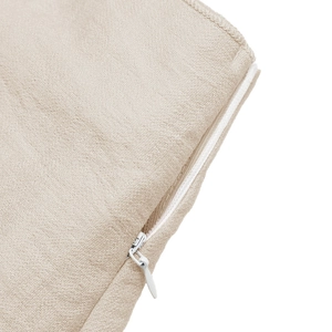 Close-up of invisible zipper detail on premium beige linen textured cushion cover