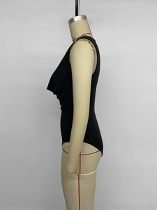 Detail view of black sleeveless bodysuit with side pleats and deep V-neckline drape
