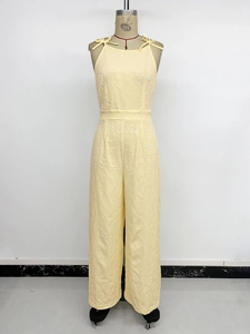 Detail showing jacquard flower fabric texture and shoulder bow ties on sleeveless jumpsuit
