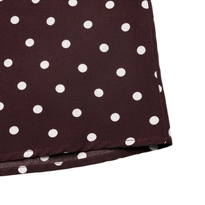 Detail of the hem stitching and white polka dot pattern on the deep red fabric
