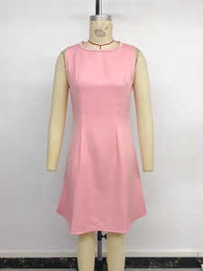 Detail of the elegant pink sleeveless dress with white pearl beads along the neckline