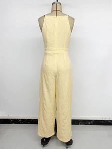 Close-up of yellow sleeveless wide-leg jumpsuit with detailed floral embossed texture