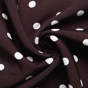 Macro detail of brown polka dot fabric showing texture and soft draping for summer dresses