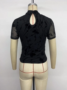 Detail view of black mesh top featuring velvet floral patterns and high neck collar